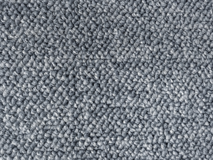 Close-up view of a gray, looped carpet texture, showing tightly woven fibers and a slightly rough, patterned surface.